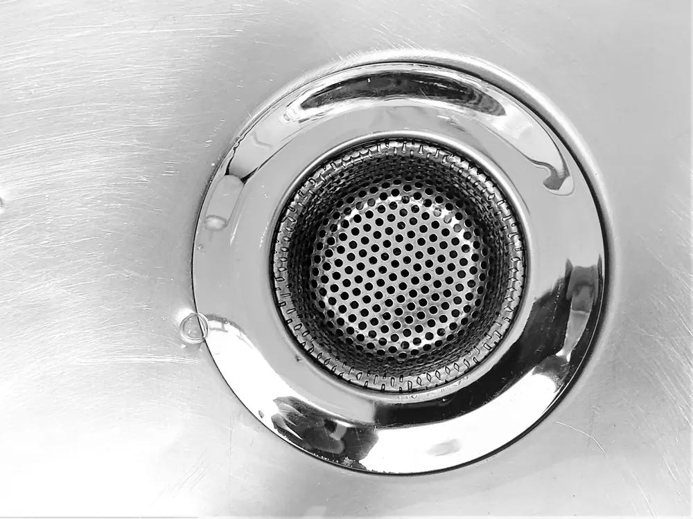 The plughole of a stainless steel sink, from above