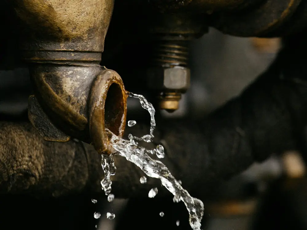 Water spraying from a joint in an old brass pipe