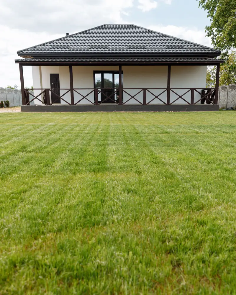 A freshly mown, striped lawn in front of a bungalow